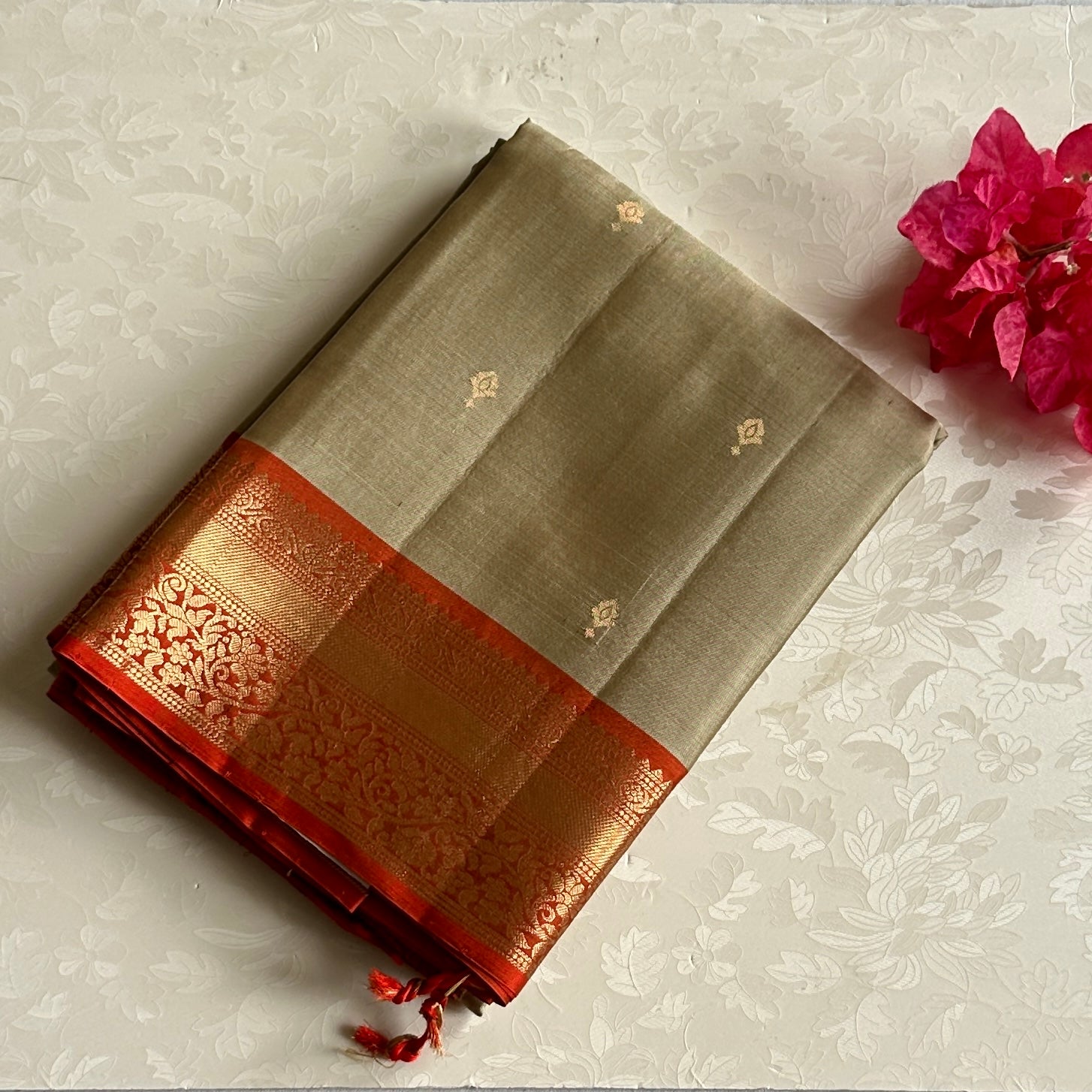 Metallic Greyish beige with stunner orange masterpiece with zari woven buttas