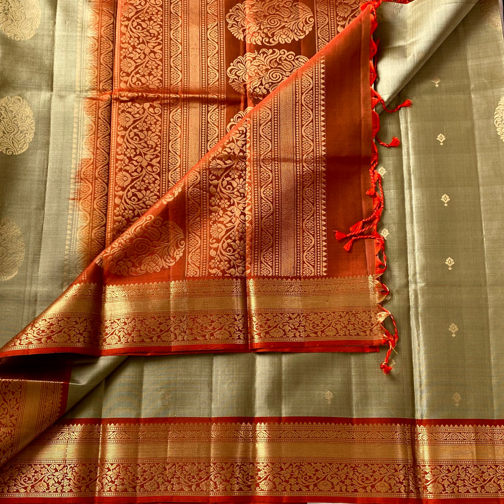 Metallic Greyish beige with stunner orange masterpiece with zari woven buttas