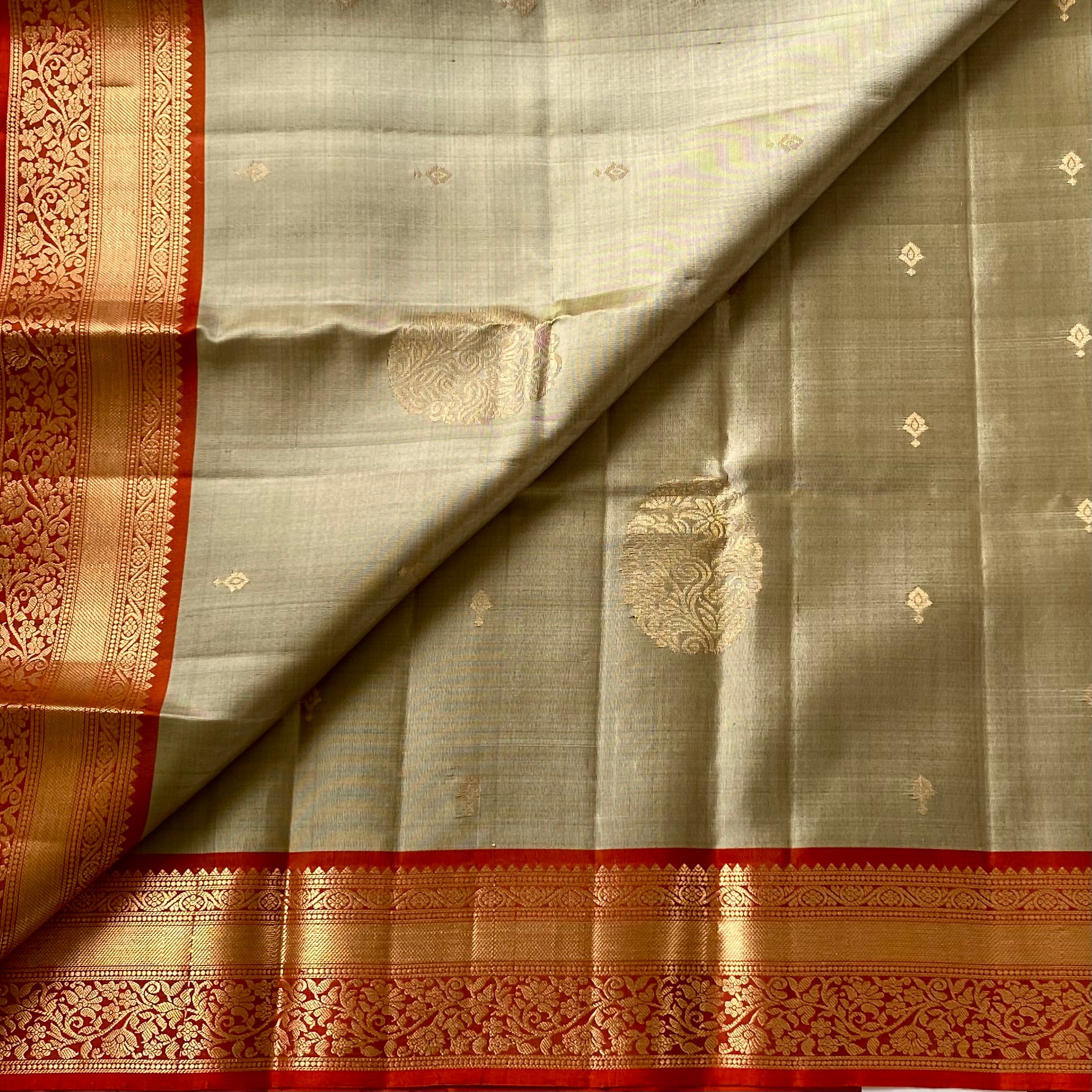 Metallic Greyish beige with stunner orange masterpiece with zari woven buttas