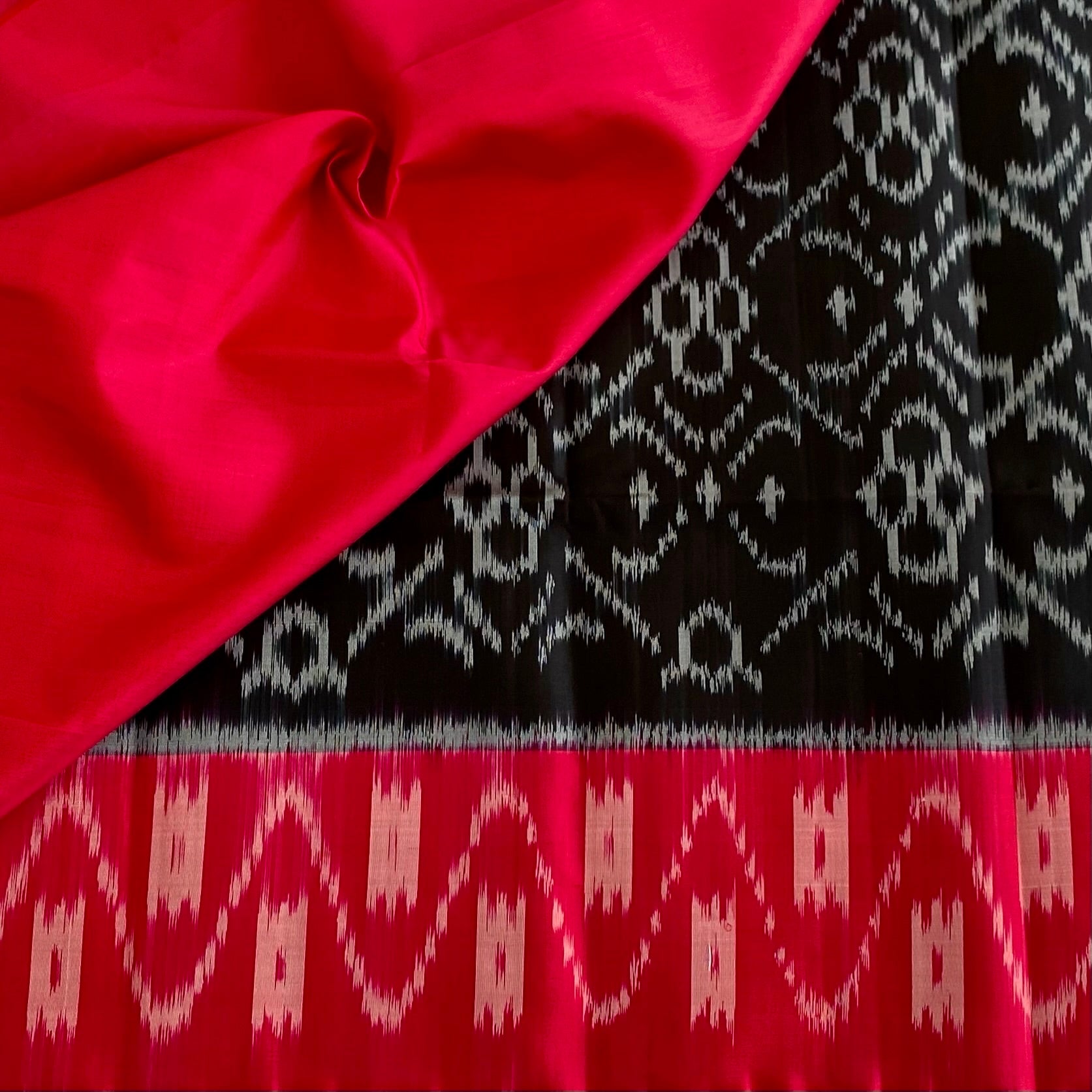 Stunner Jet Black Designer Ikkat Woven Pure silk with Tomato Pink Borders & Pallu