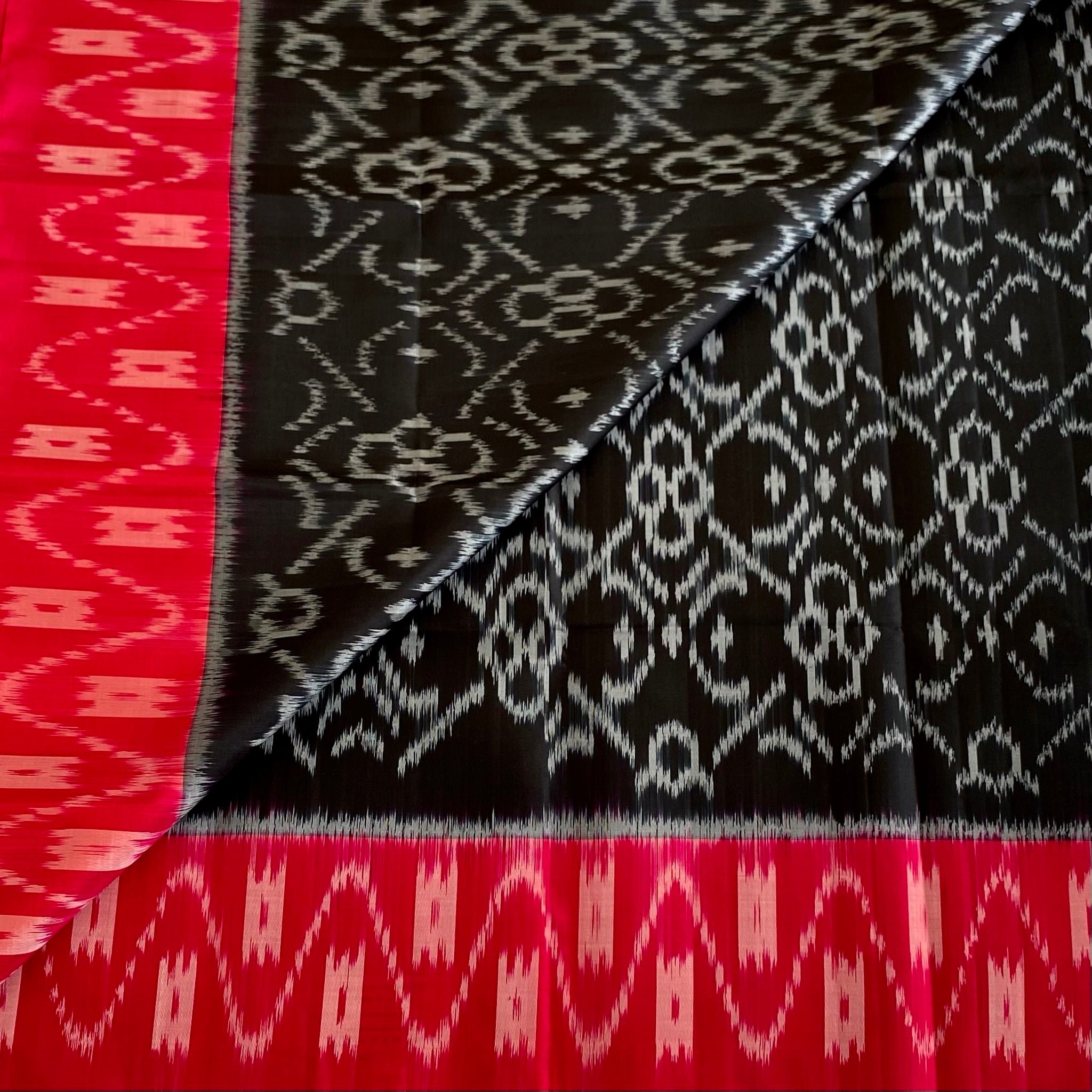 Stunner Jet Black Designer Ikkat Woven Pure silk with Tomato Pink Borders & Pallu