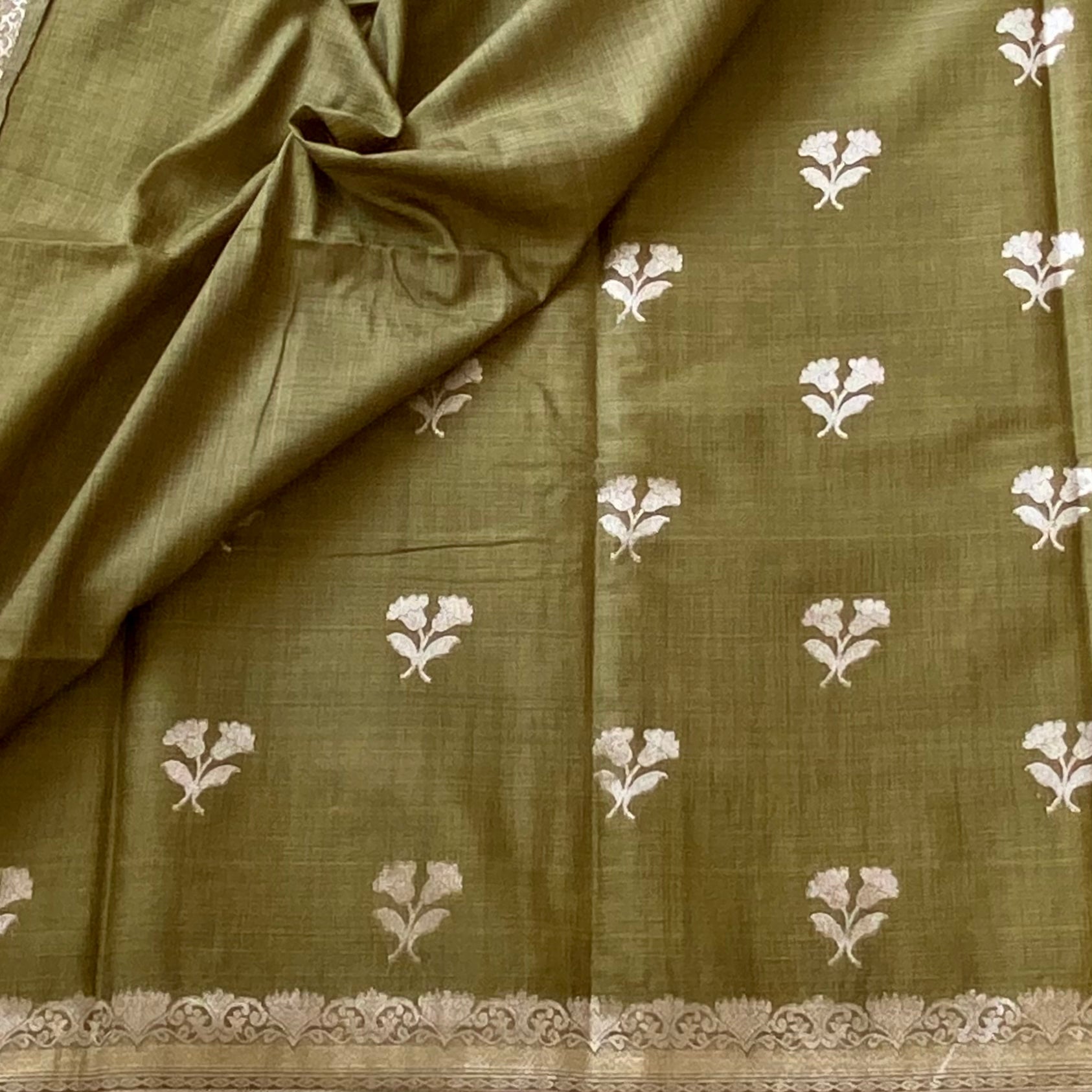 Olive Green soft tussar with antique silver buttas and lotus borders